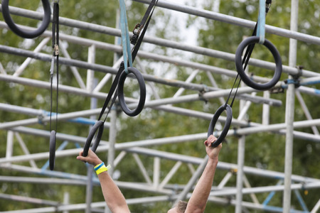 A person on hanging rings during an adventure obstacle course race