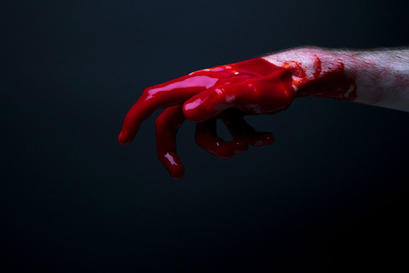 Bloody hand against a dark background. halloween horror conceptの写真素材