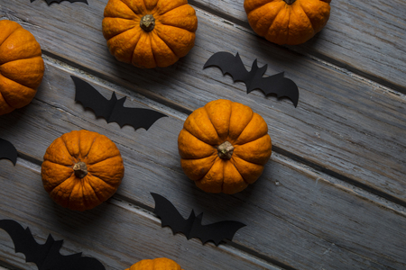 Halloween pumpkins and black vampire bats on a wooden backgroundの写真素材