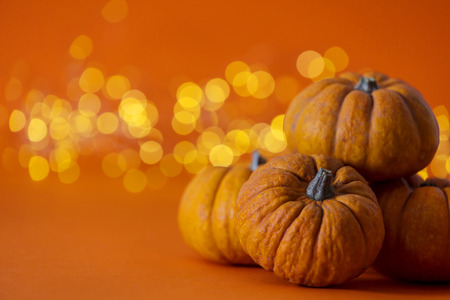 Halloween pumpkins against bright orange blurred lights background