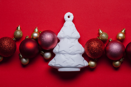 White Christmas tree and festive bauble decorations on a red backgroundの写真素材