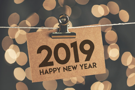 2019 new year sign pegged to a string with blurred bokeh lights in the background