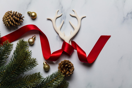 Seasonal winter background with antlers, fir branches and red ribbonの写真素材