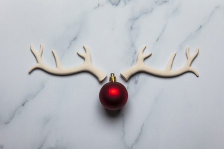 Christmas reindeer face made from antlers and bauble on a marble backgroundの写真素材