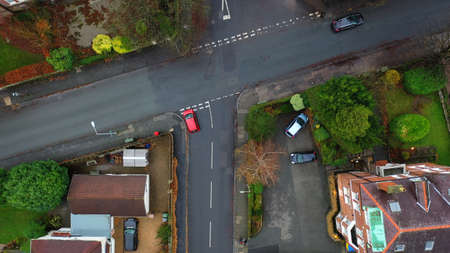 Aerial view of vehicles travelling on roads in the suburbs in a town in the UK