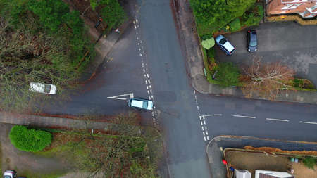 Aerial view of vehicles travelling on roads in the suburbs in a town in the UK