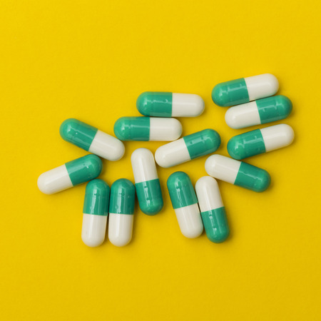 Prescription antibiotic drug medication pills on a bright colourful background. Health care concept