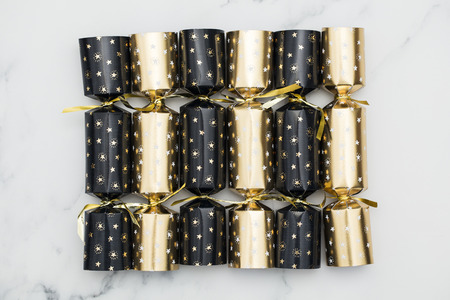Christmas crackers. luxury gold and black festive crackers on a marble backgroundの写真素材