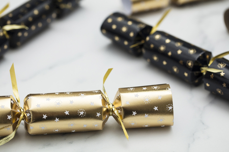 Christmas crackers. luxury gold and black festive crackers on a marble backgroundの写真素材
