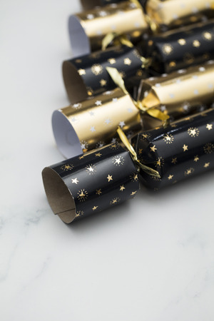 Christmas crackers. luxury gold and black festive crackers on a marble backgroundの写真素材