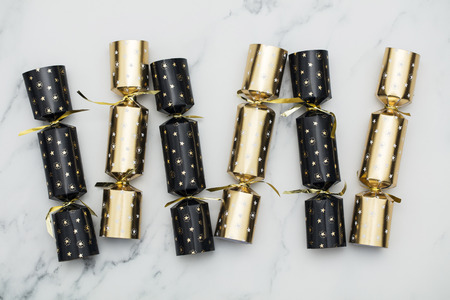 Christmas crackers. luxury gold and black festive crackers on a marble backgroundの写真素材