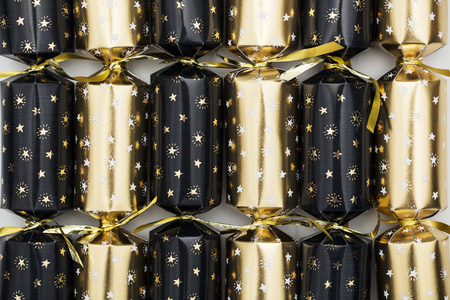 Christmas crackers. luxury gold and black festive crackers on a marble backgroundの写真素材