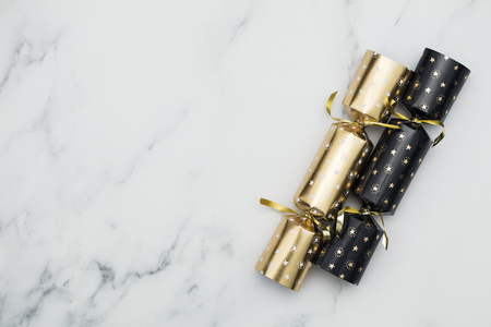 Christmas crackers. luxury gold and black festive crackers on a marble backgroundの写真素材