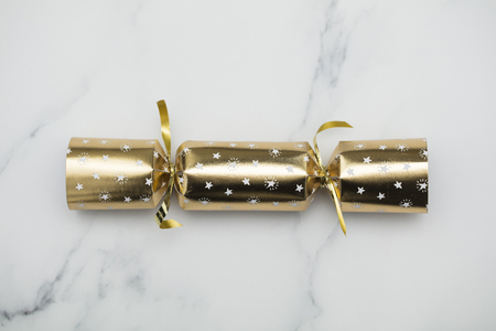 Christmas crackers. luxury gold and black festive crackers on a marble backgroundの写真素材