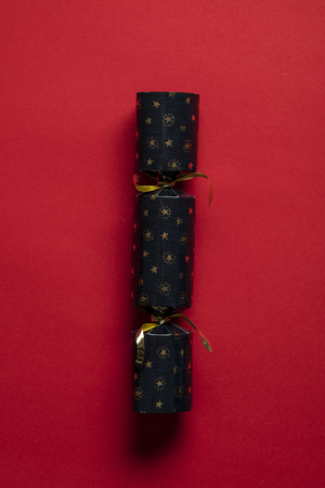 Festive Christmas crackers on a bright red backgroundの写真素材