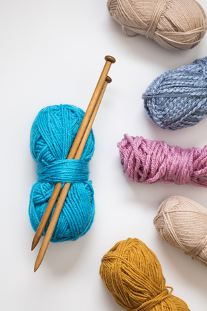 Knitting background. Balls of wool and knitting needles on a plain backgroundの写真素材