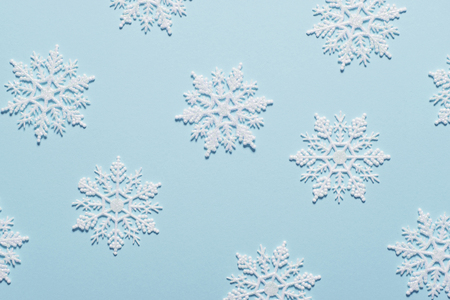 White glitter snowflake composition on a pastel blue backgroundの写真素材