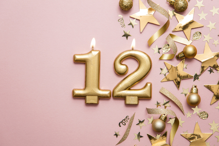Number 12 gold celebration candle on star and glitter backgroundの写真素材