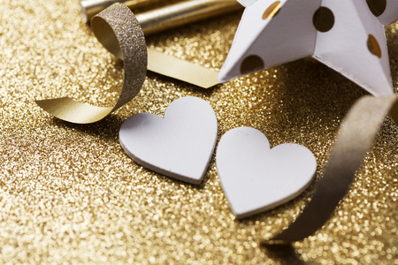 White heart shape on a golden glitter backgrondの写真素材
