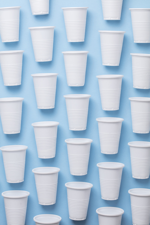 Single use white plastic cups on a blue backgroundの写真素材