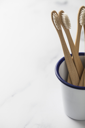 Wooden bamboo toothbrush in a white potの写真素材