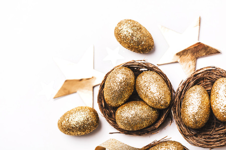 Golden glitter eggs in a nest. Easter background. Finance concept