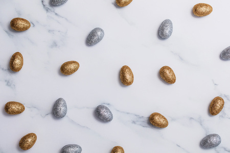 Gold and silver glitter easter eggs on a marble backgroundの写真素材