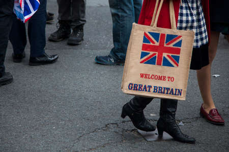 A woman holing a welcome to Great britain shopping bagの写真素材