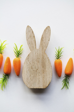 Wooden easter bunny with orange carrotsの写真素材