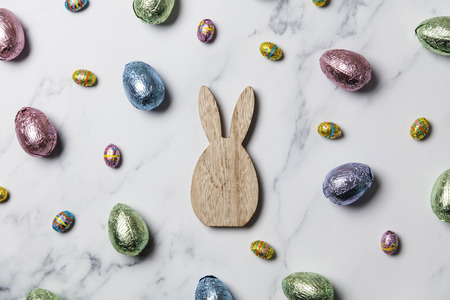 Easter bunny with foil wrapped chocolate easter eggsの写真素材