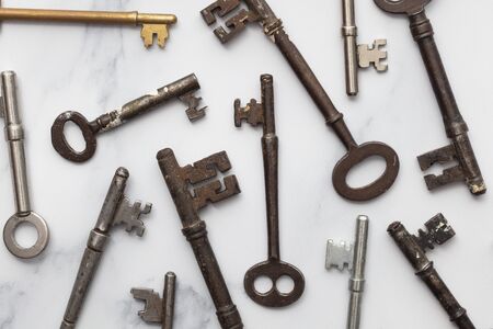 Large set of vintage keys on a plain background. Safety and security concept