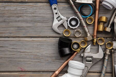 Plumbing tools, pipe and fixings on a rustic wooden background. Home improvementの写真素材