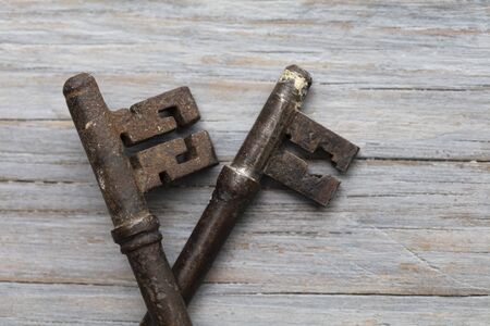 Vintage old fashioned keys on a rustic wooden background. Security concept