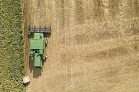 Aerial view over a green combine harvester in a farm fieldの写真素材
