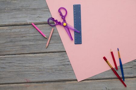 Creative hobby art supplies on pink paper. Overhead desk composition