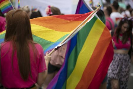 LONDON, UK - July 6th 2019: People wave LGBTQ gay pride flags at a solidarity march