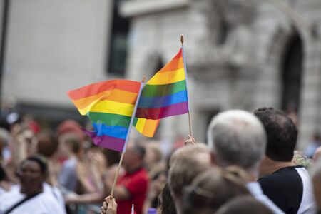 Spectators waves a gay rainbow flag at an LGBT gay pride community event