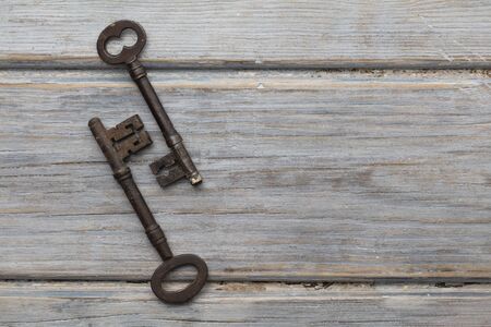 Vintage old fashioned keys on a rustic wooden background. Security concept