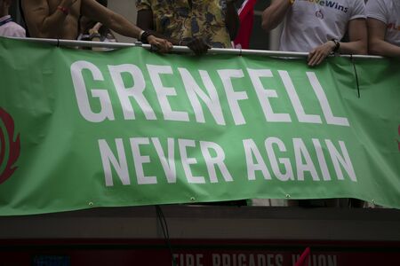 LONDON, UK - July 6th 2019: People hold a Grenfell never again sign in memory of the genfell tower...