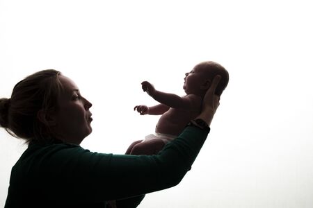Silhouette of a mother holding her newborn baby