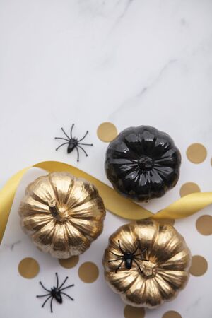 Luxury gold and black autumn pumpkin flat lay composition on a marble backgroundの写真素材
