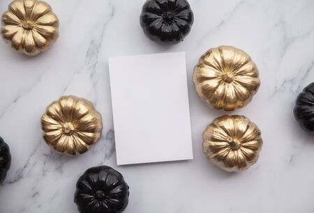 Luxury gold and black autumn pumpkin flat lay composition on a marble backgroundの写真素材