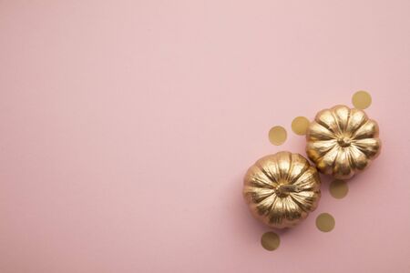 Beautiful golden pumpkins on pastel pink. Flat lay thanksgiving compositionの写真素材