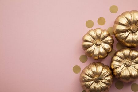 Beautiful golden pumpkins on pastel pink. Flat lay thanksgiving compositionの写真素材