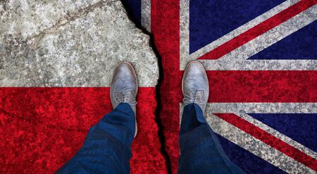 Business man stands on cracked flag of UK and Poland. Political conceptの写真素材