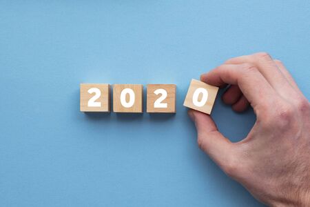 Hand placing wooden cubes. New year 2020 background