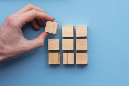 Hand choosing a wooden block from a set. Business choice conceptの写真素材