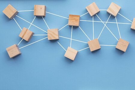 Wooden blocks connected together on a blue background. Teamwork conceptの写真素材