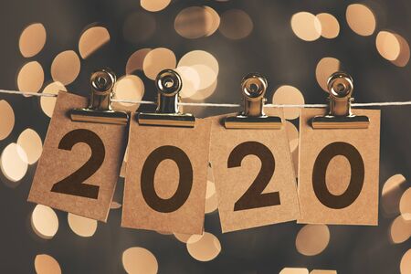 2020 new year sign pegged to a string with bokeh lights in the backgroundの写真素材