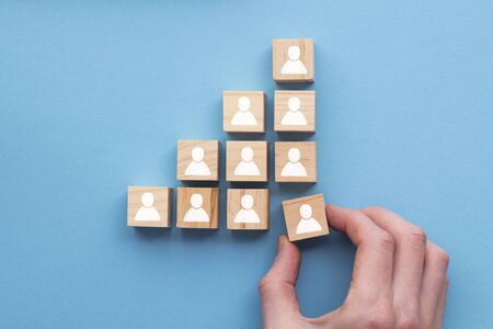 Hand adding a new team member to a group. Business management concept